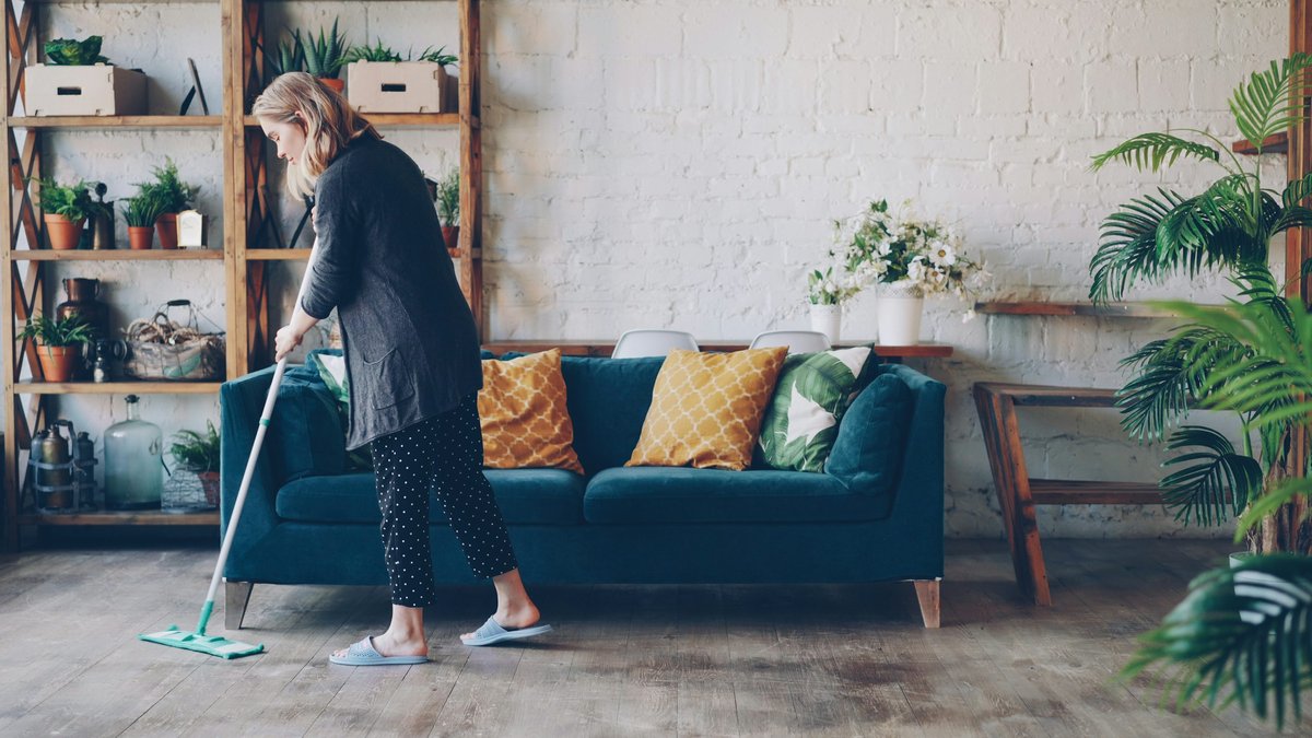 Illustrative photo of a person mopping a living-room floor